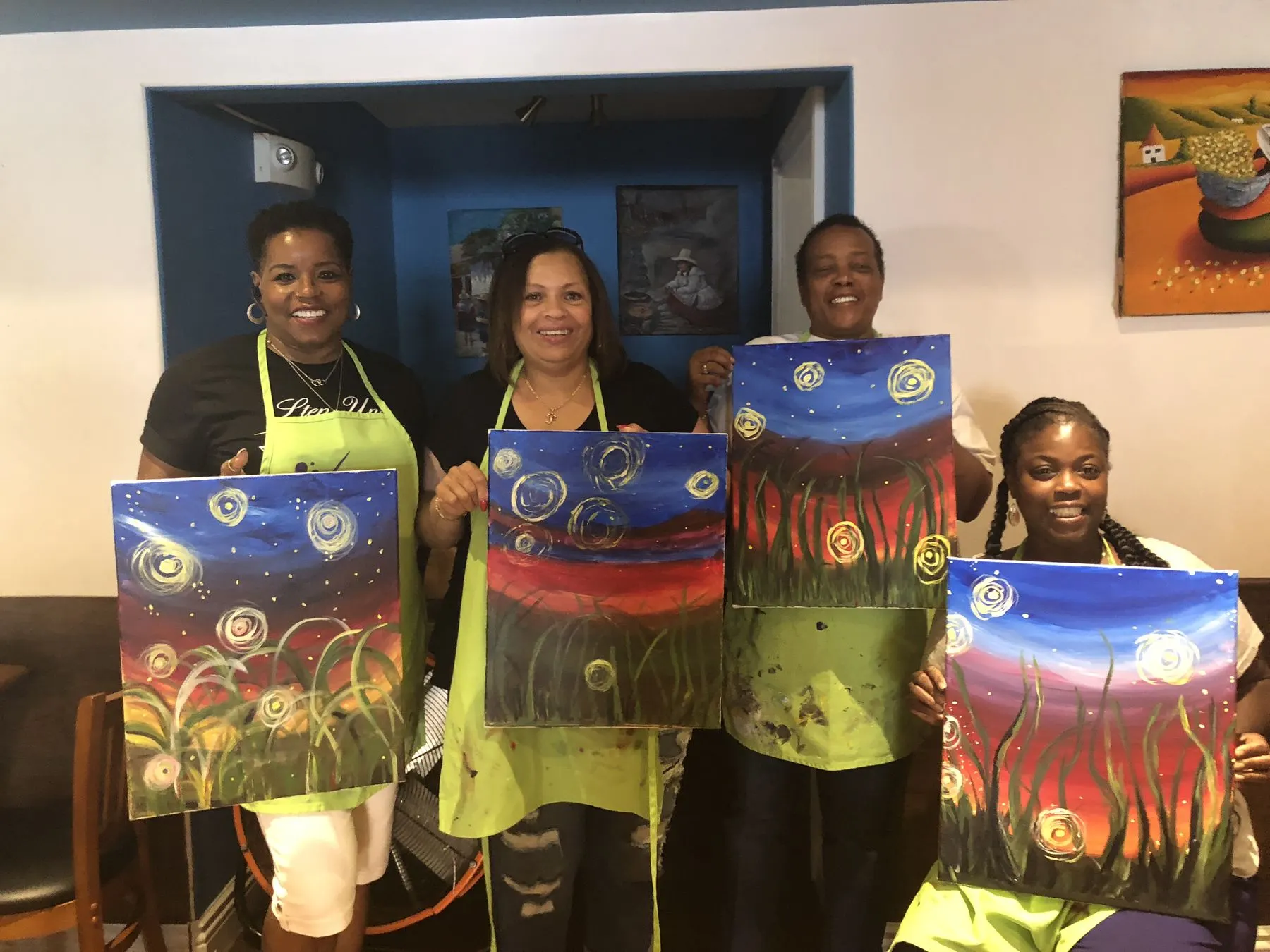 Members holding the paintings they made together