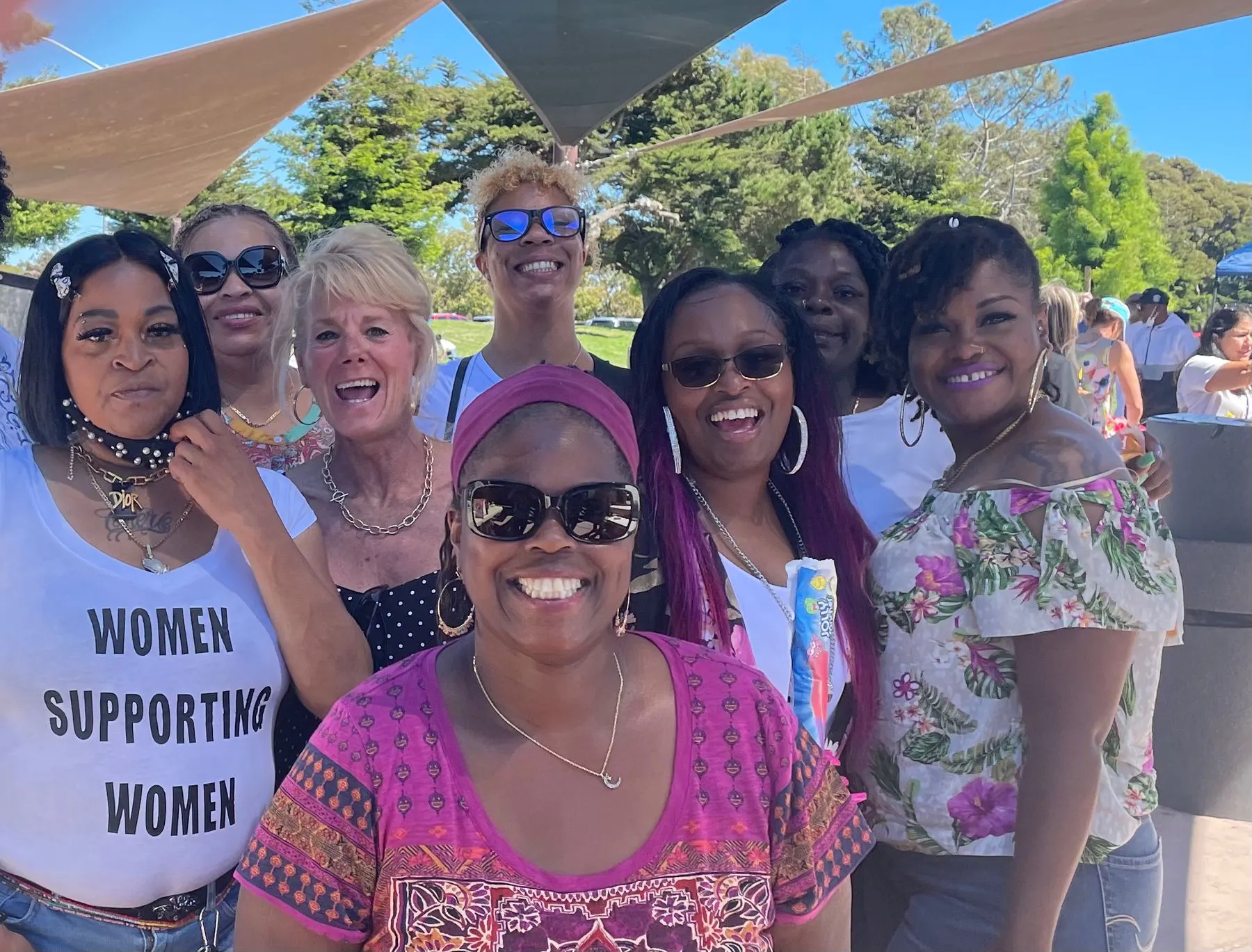 Members in Women Supporting Women shirts at an outdoor gathering