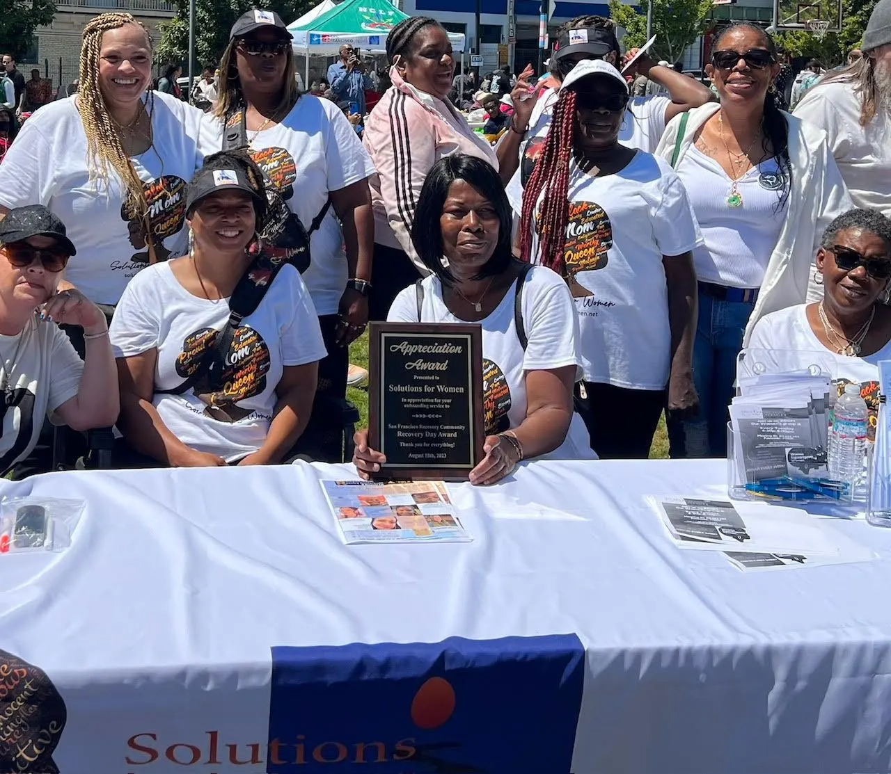 Members at the Recovery Day table with the Appreciation Award