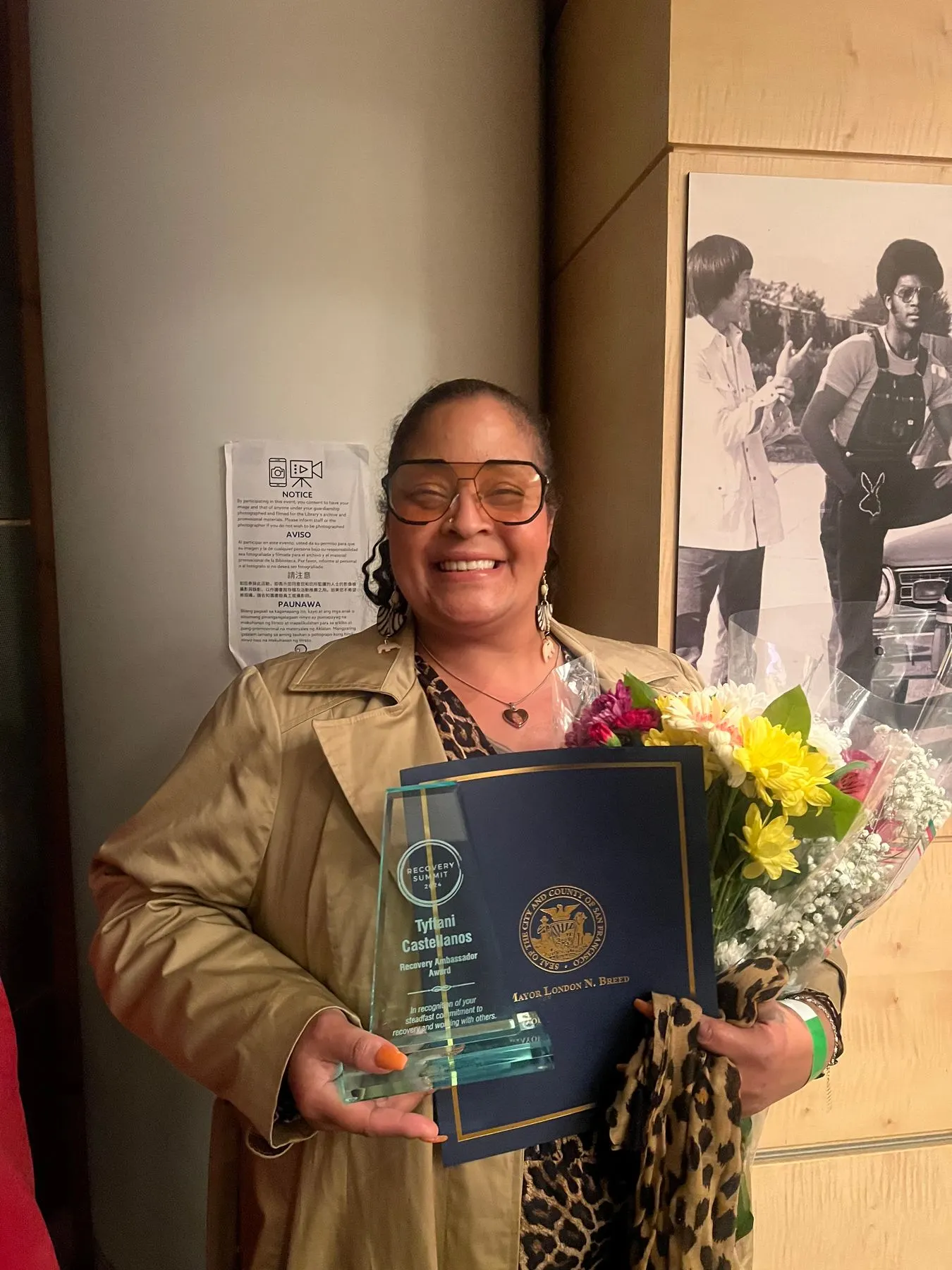 A member holding her award and bouquet