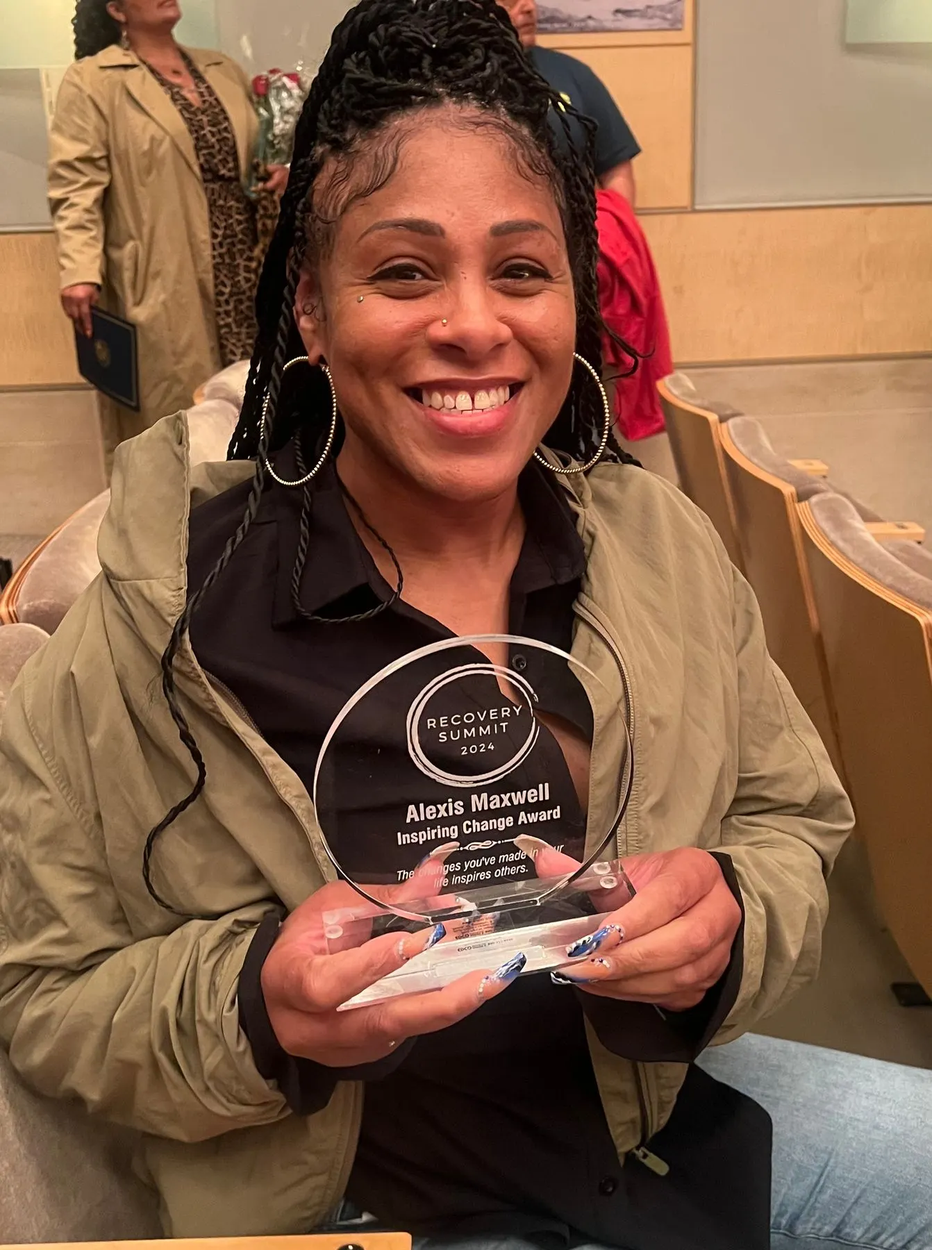 A member holding her Inspiring Change award