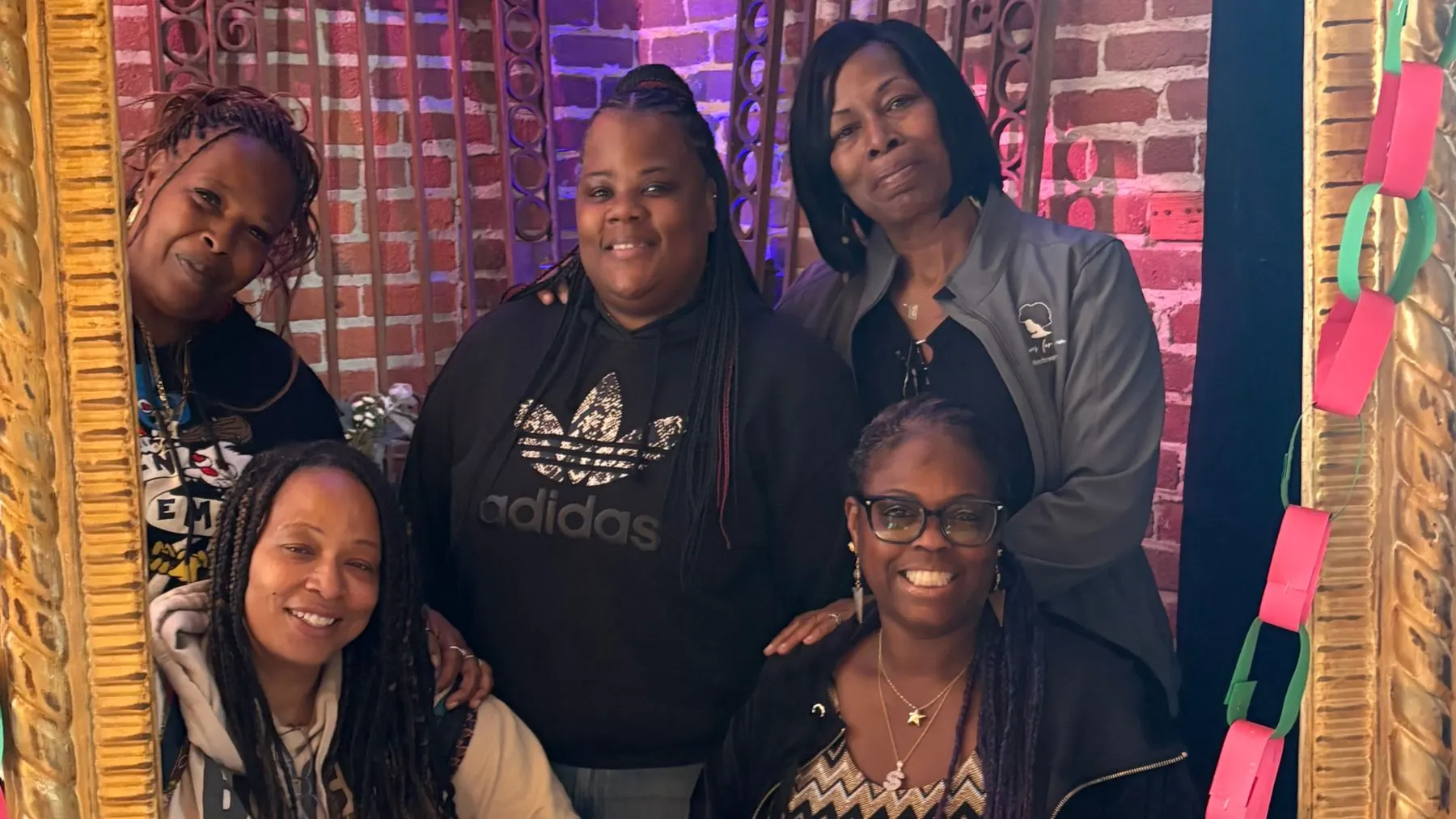Members of Solutions for Women smiling together inside a festive holiday frame